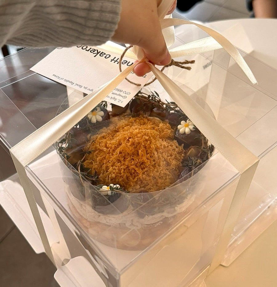aaaxsss는 기와지붕 아래 하얀 벽돌 외관부터 담았습니다. 유리문에 붙은 동그란 로고와 'COFFEE / CAKE' 간판이 골목 모퉁이에서도 눈에 띕니다.