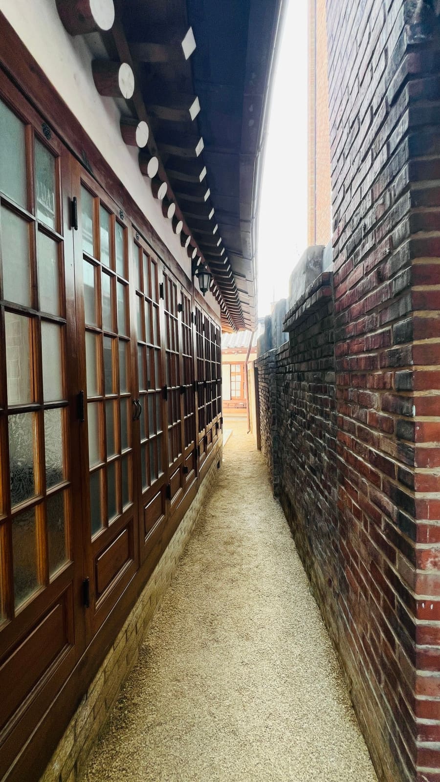 서촌 골목의 한옥 구조. 전통적인 나무 기둥과 기와지붕, 창호가 그대로 남아있고, 골목은 경복궁 방향으로 열려있다.