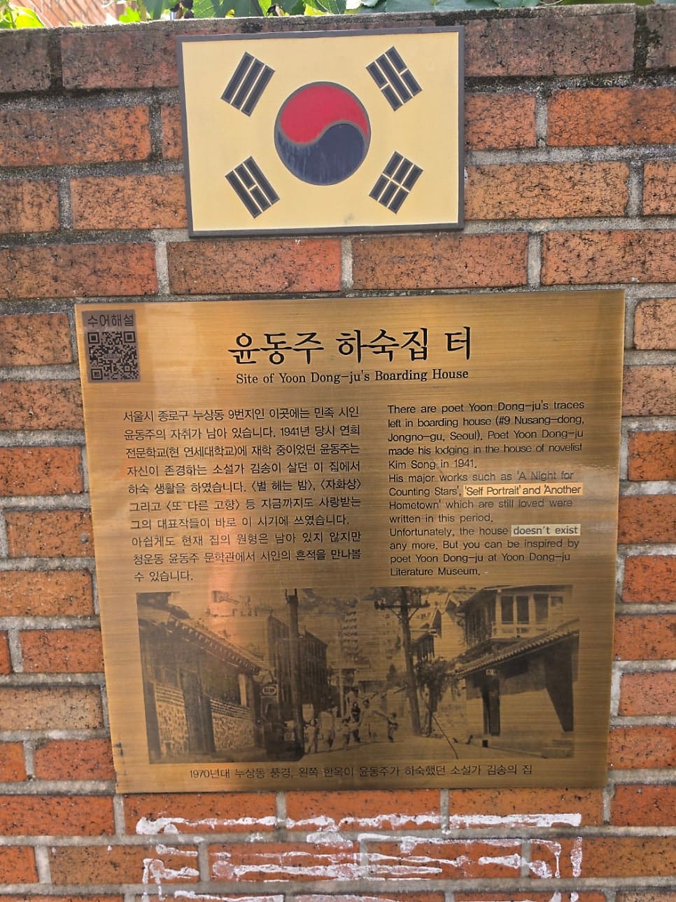 서촌 골목의 역사와 문학. 시인 윤동주가 살았던 하숙집 터와 인문학적 의미를 담은 안내판. 낡은 벽돌 담장 위에 붙은 이 패널은 과거와 현재를 잇는 통로 역할을 한다.