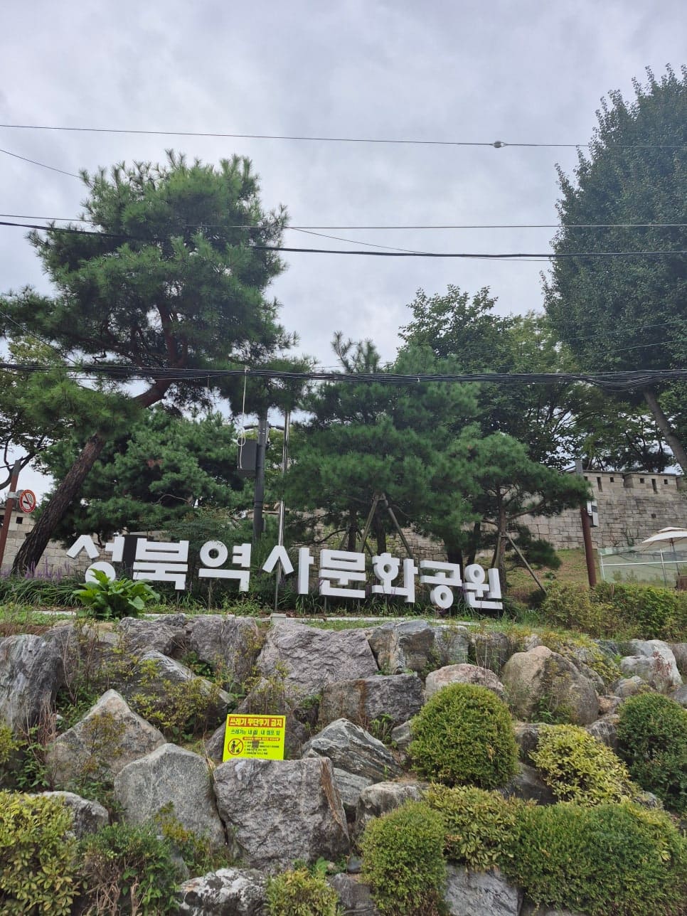 ksana0013이 촬영한 성북역사문화공원 표지석과 뒤편 성곽, 그리고 오르막 골목의 주택가 풍경입니다. 어영청 북둔에서 시작된 동네의 지형을 짐작하게 합니다.