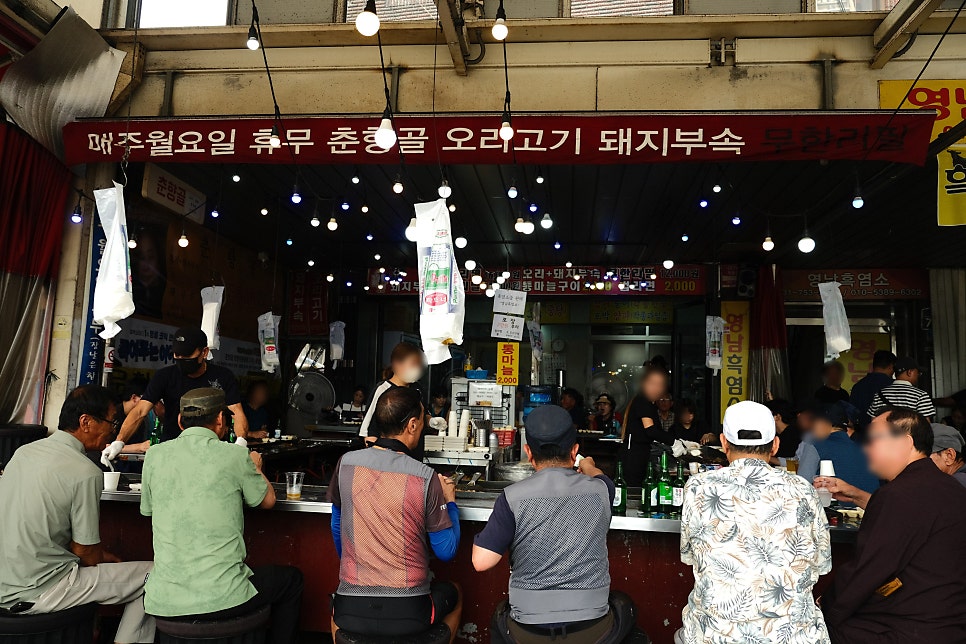 youngtae_car가 촬영한 춘향골의 야장 자리와 철판 위 돼지부속입니다. 손님들이 나란히 앉아 고기를 구워 먹는 풍경과,