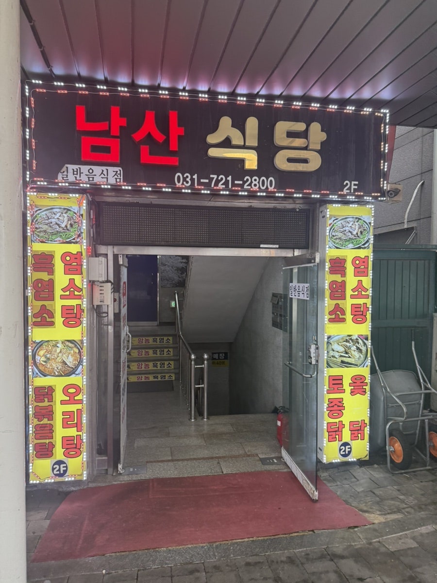 possess90이 촬영한 남산식당 외관입니다. 흑염소전문점·보양식·삼계탕 간판이 붙은 2층 건물과, 흑염소탕·오리탕·토종닭 메뉴가 적힌 출입구 간판을 함께 담았습니다.