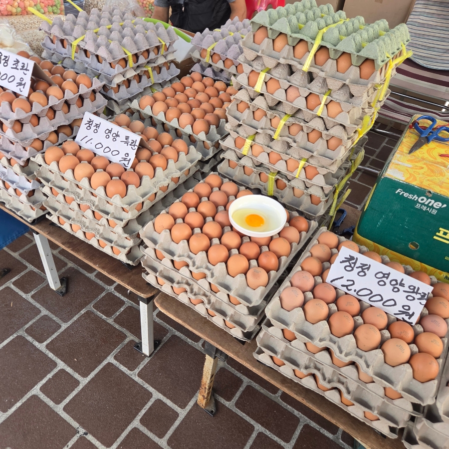 doremifas_ol이 찍은 뻥튀기 과자 좌판과 계란 더미입니다. 비닐봉지에 담긴 강정과 뻥튀기, 층층이 쌓인 계란판까지,