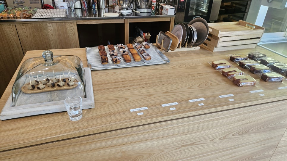 lsb9199이 촬영한 세설의 메뉴판과 디저트 진열대입니다. 커피와 티, 휘낭시에 같은 구움과자 가격이 적힌 손글씨 메뉴판과,
