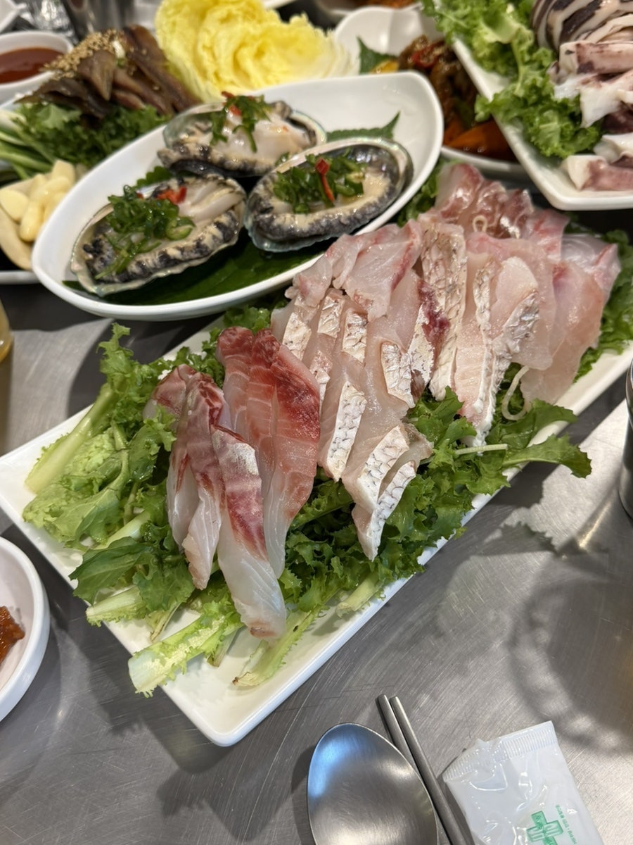 같은 분이 남긴 해산물 접시 사진입니다. 전복과 다양한 생선회가 깻잎, 레몬과 함께 수북이 담겨 있어, 기본 5만원 정식으로도 충분했다는 그 말이 접시 위에서 그대로 느껴집니다.