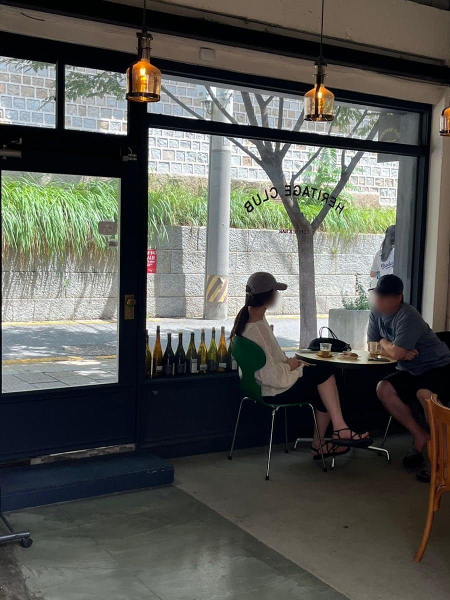 seven422는 서순라길에서 유럽 느낌이 나는 카페를 발견했다며 외관이 너무 예뻐서 고민 없이 들어갔다고 적었습니다. 첫 사진에는 남색 문틀의 가게 앞과 입간판,