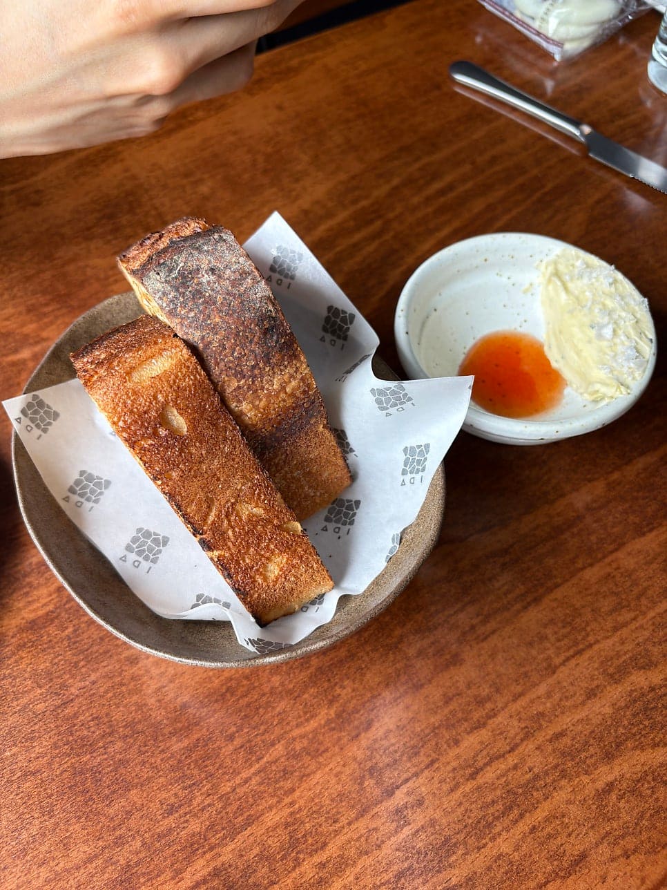 yoonhee523523은 이 빵을 먹고 진짜 감동했다며, 겉바속촉이라 너무 맛있었다고 적었습니다. 두 사진 모두 IDA 로고가 찍힌 종이에 싸인 샤워도우와,