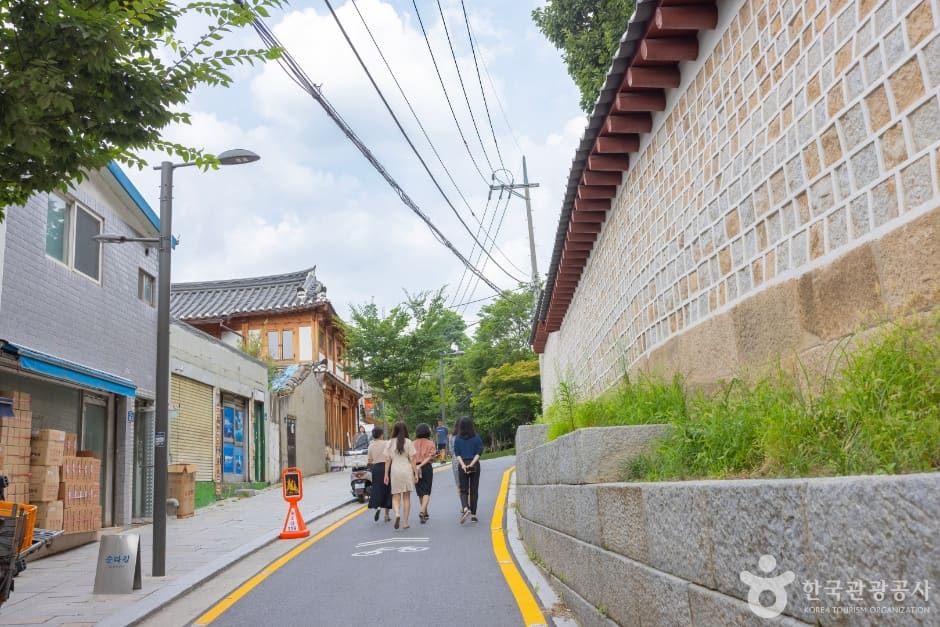 왼쪽으로 한옥과 상점이 늘어서 있고 오른쪽으로 종묘의 붉은 기와를 얹은 돌담이 이어지는 서순라길입니다.