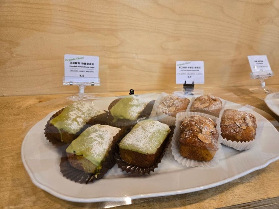 마들렌과 스콘이 가득한 진열대에 'Organic Flour' 팻말이 나란히 붙어 있습니다.