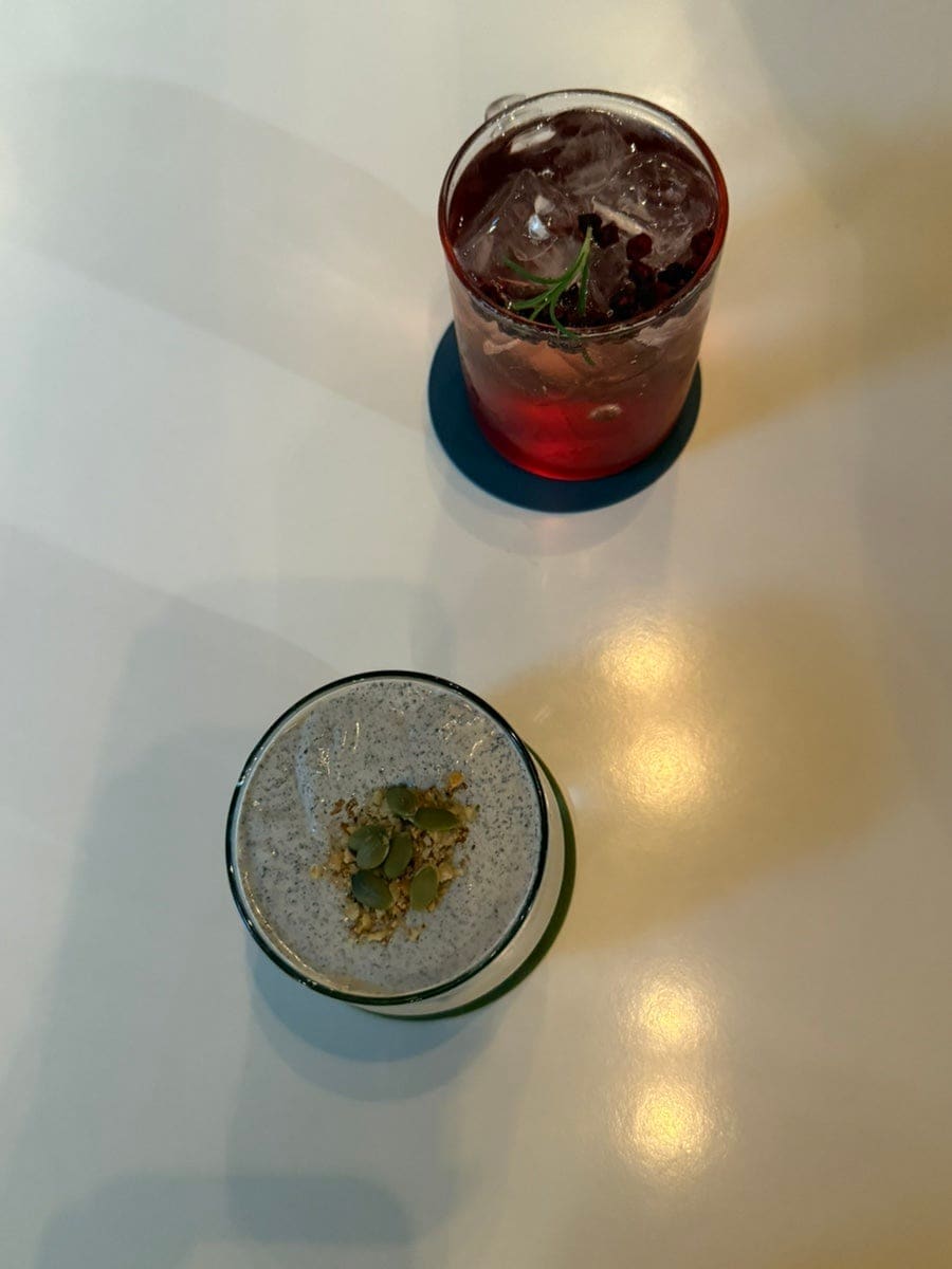 hodushu는 두디라떼와 문경 오미자 에이드를 함께 놓고 고소한 크림과 오미자의 붉은빛이 대비돼 색감이 예뻤다고 적었습니다. 사진은 하얀 테이블 위에서 내려다본 두 잔으로,