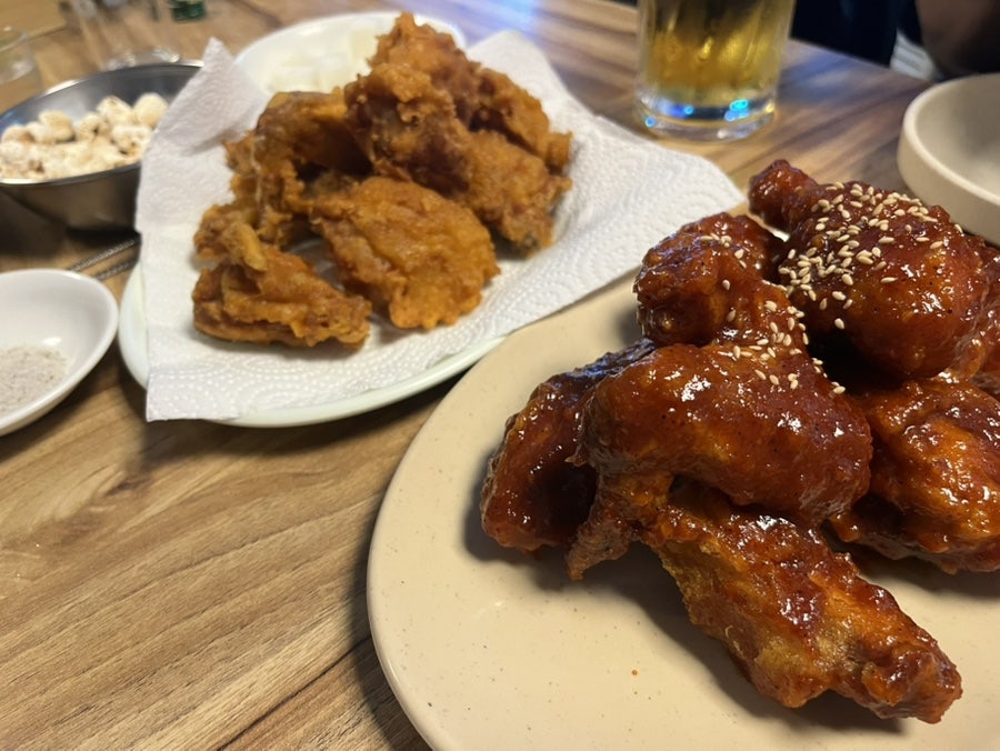 cdh1157k는 손님으로 가득 찬 홀과, 후라이드와 양념치킨을 반반 담은 접시를 찍었습니다. 동네 주민들이 편하게 맥주 한잔 하러 오는 분위기라고 적었습니다.