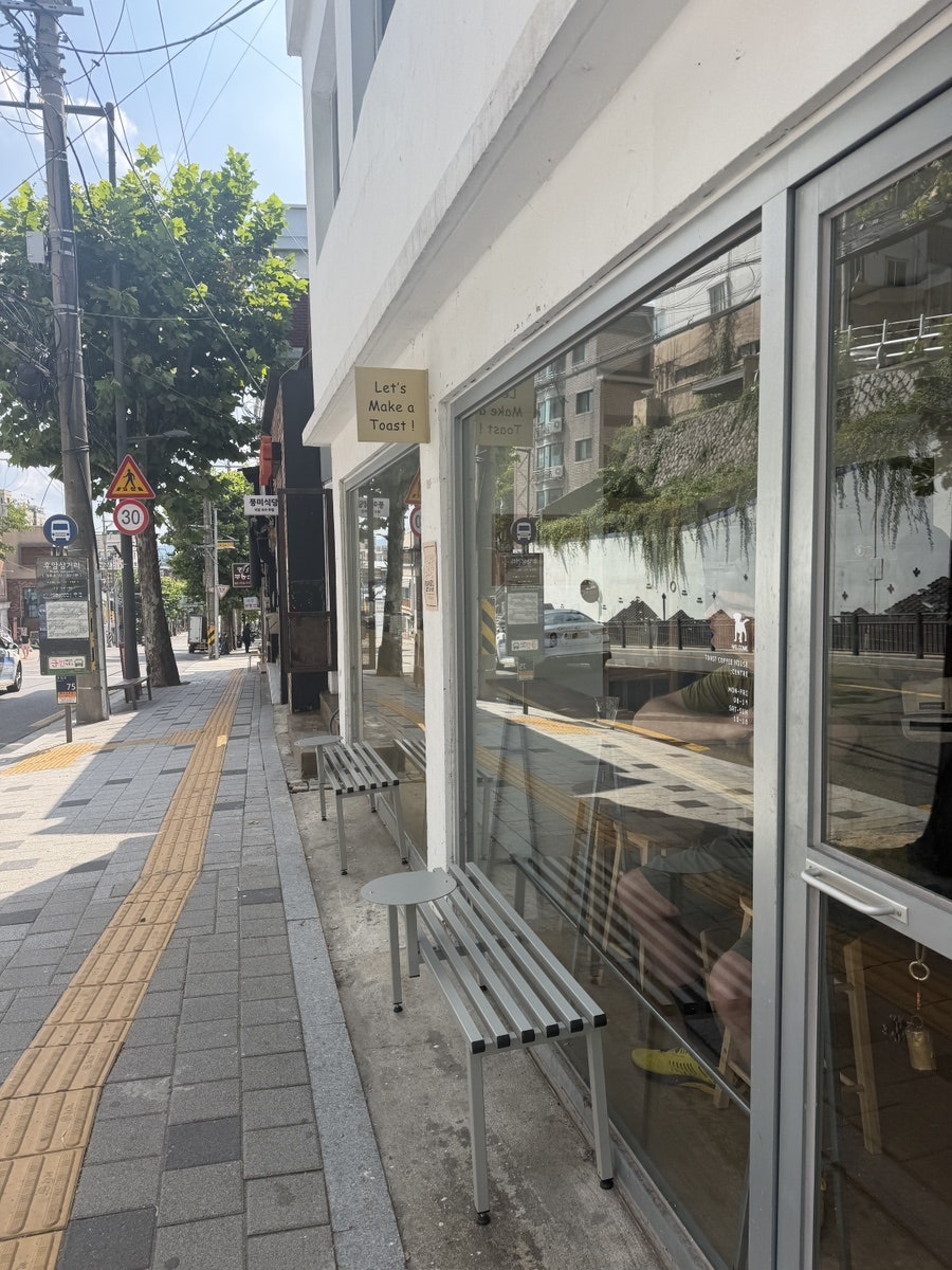 dangamhongsi는 가게 밖 벤치가 놓인 골목길과 쿠키·바나나브레드가 놓인 진열대를 찍었습니다. 강아지 환영 카페라 머무는 동안 강아지들이 오갔다고 적었습니다.