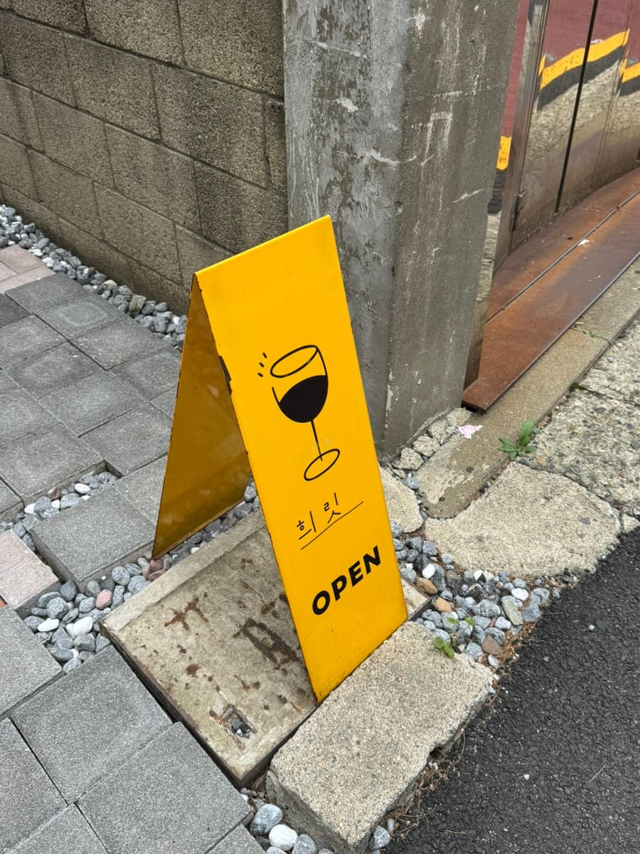 골목 사이로 들어오다 보면 아늑한 가정집을 개조한 건물이 보인다고 적은 방문자입니다. 길가에 세워진 노란 입간판이 입구를 찾는 표식이고,