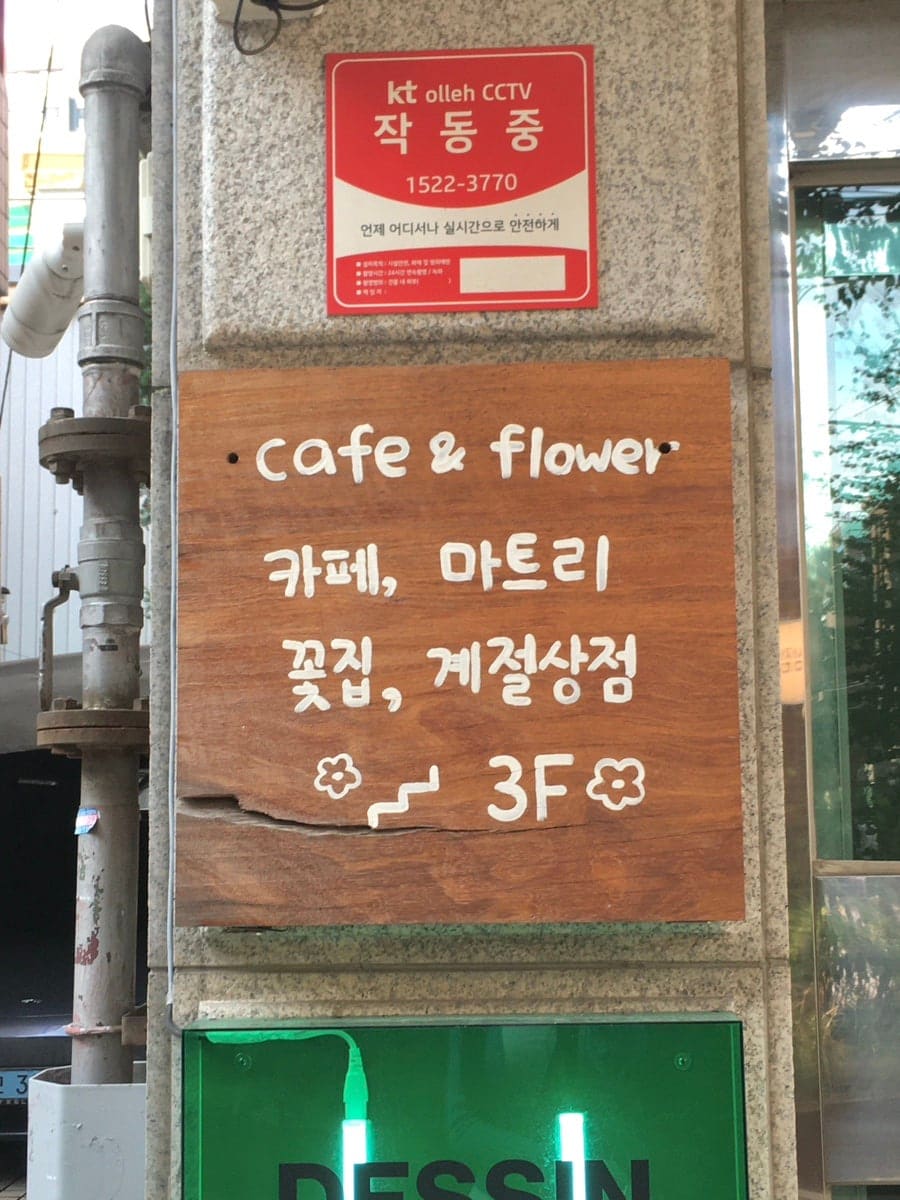골목 쪽에 입간판이 있어 찾는 게 어렵지 않았고, 계단을 따라 올라가면 우드톤 문과 식물이 먼저 보여 들어가기 전부터 분위기가 예뻤다고 적은 방문자입니다.
