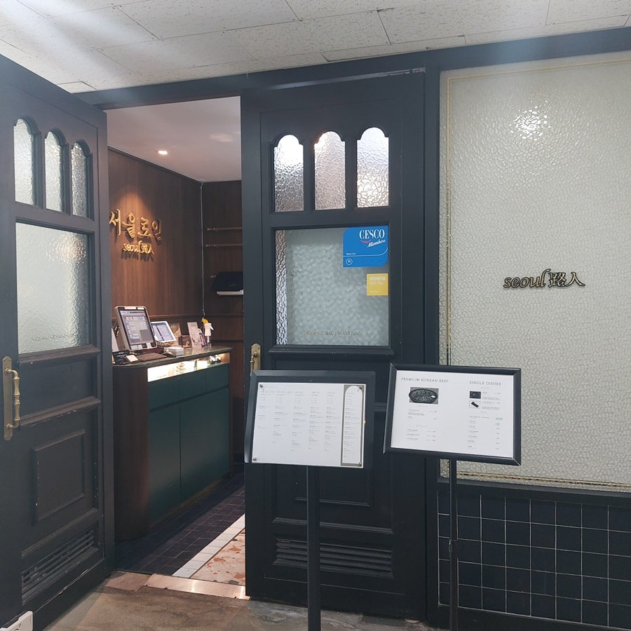 고급스러운 입구 앞에 대기 공간과 메뉴 안내 입간판이 놓여 있다고 적었습니다. '서울로인 seoul路人' 간판 아래로 카운터와 직원이 보이는 구조라,