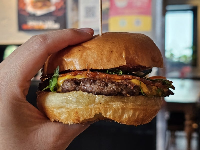 burgertraveller가 찍은 돌솥비빔밥버거 단면입니다. 패티와 나물, 고추장 눌은밥까지 층층이 보이는데,