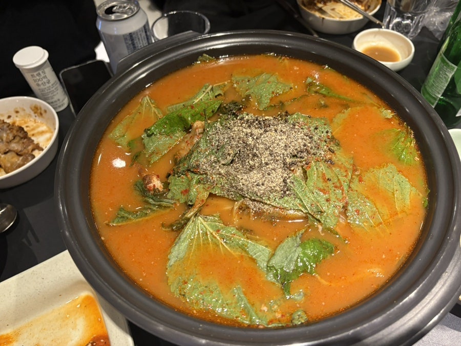 minchae98은 치즈랑 뼈찜 때깔이 너무 곱다고 적었습니다. 메뉴 포스터가 놓인 창가 테이블 사진 다음에는, 깻잎과 들깨가루를 수북이 올린 매콤한 감자탕 한 그릇이 이어집니다.