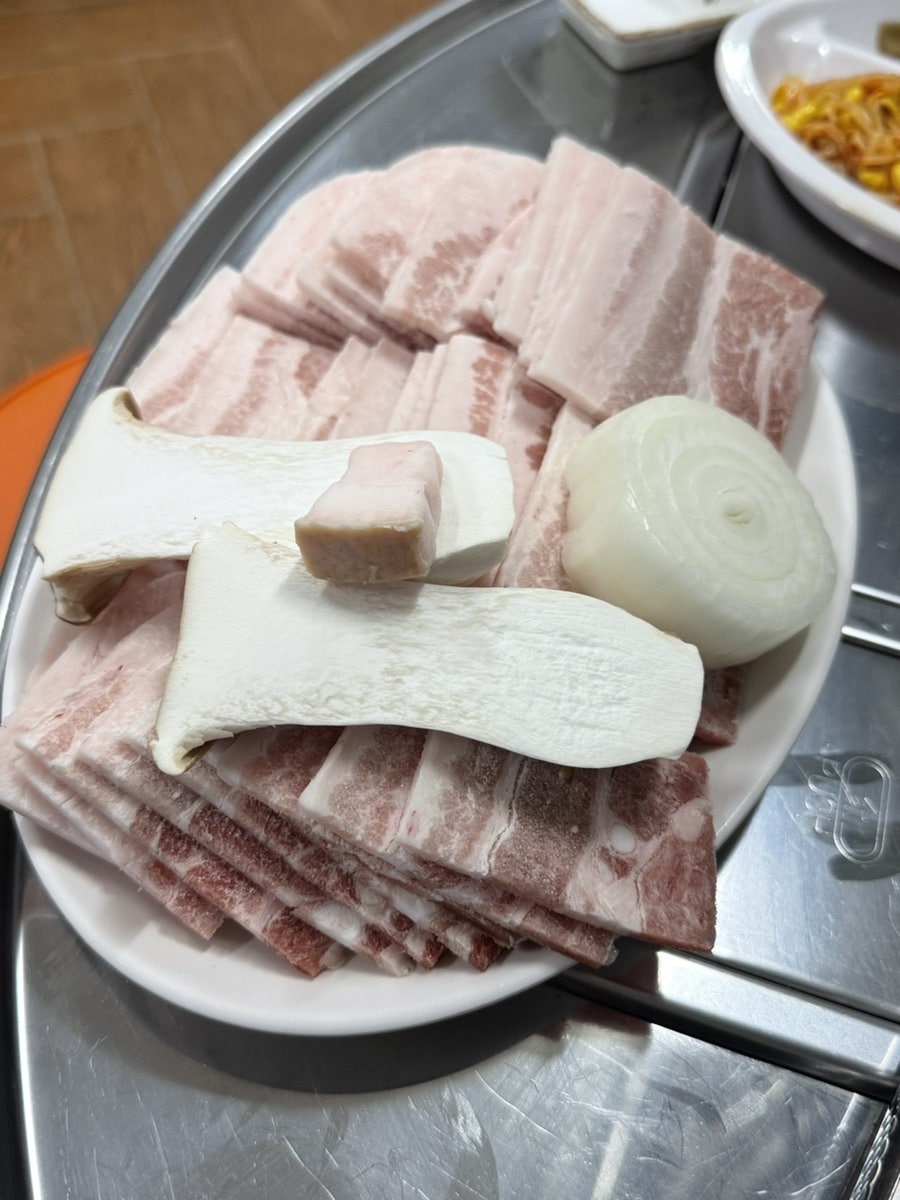 생삼겹 300g과 껍목살 300g, 다섯 근도 안 되는 가격에 고기 600g과 찌개까지 나온다고 적었습니다. 느타리버섯과 양파가 곁들여진 고기 접시가 그 말을 그대로 보여줍니다.