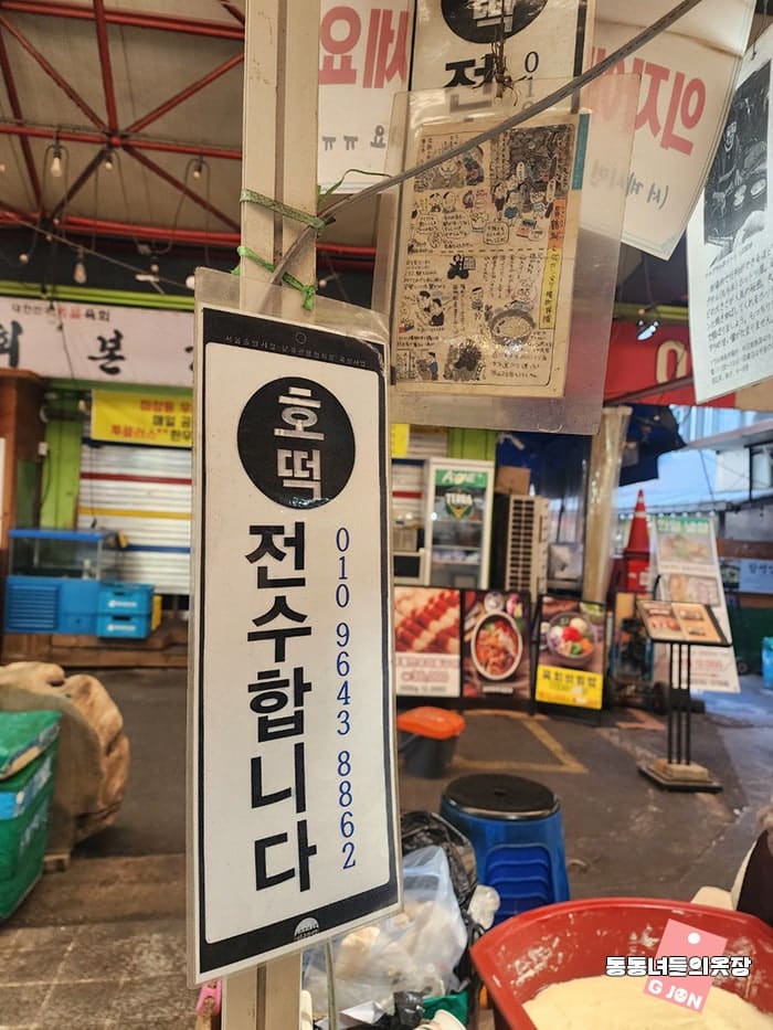 신당동 골목의 저녁거리. 시장의 오래된 간판들이 밝혀지고, 그 옆으로 새로운 식당과 카페의 따뜻한 조명이 함께 보인다.