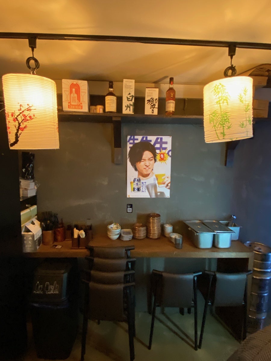 al_dente는 중앙시장이 한순간에 일본이 되는 매직이라고 적었습니다. 사진에는 시장 철골 지붕 아래 횡정(横丁)이라 적힌 요코초 간판과 해 그림이 그려진 노렌이 걸린 외관,