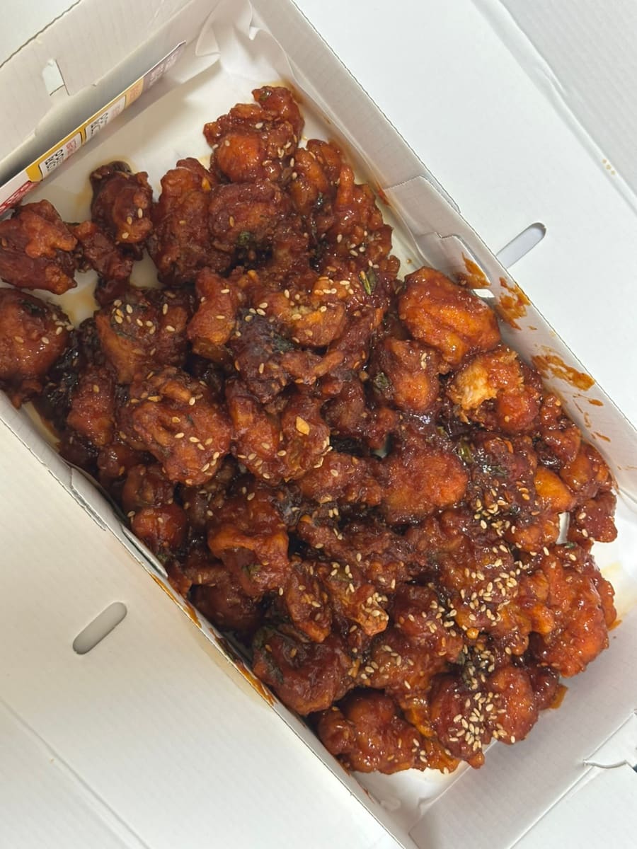 pigzzangg가 상자를 열어 찍은 닭강정에는 깨가 고루 뿌려져 있고, 짙은 양념이 윤기를 내며 엉겨 있습니다.