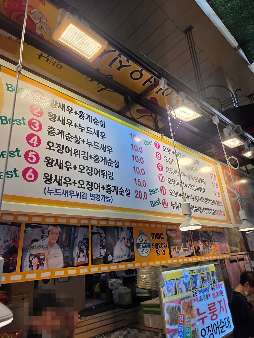 rice7752가 올려다보고 찍은 조합 메뉴판에는 '왕새우+홍게순살' 같은 조합이 번호와 함께 나열돼 있고, 아래쪽에는 방송 출연 장면이 필름 띠 모양으로 붙어 있습니다.