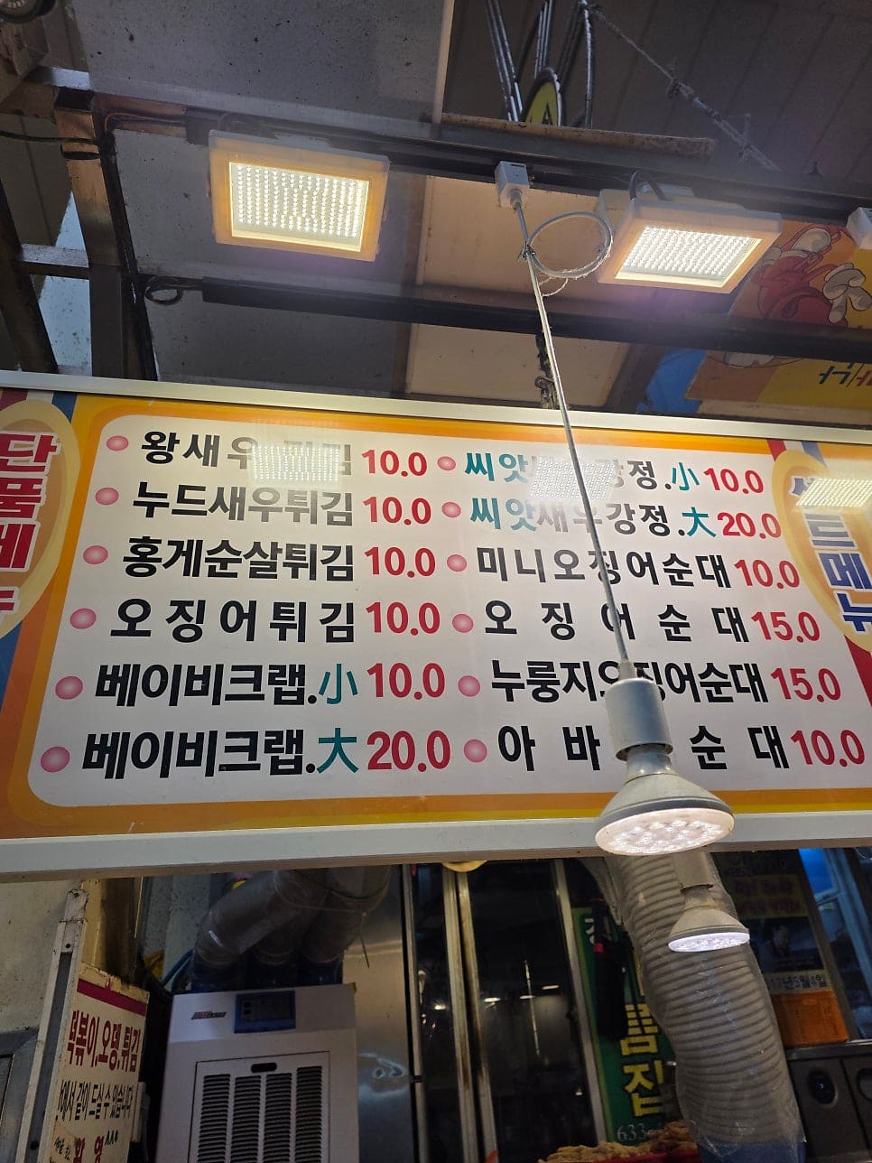 rice7752가 올려다보고 찍은 조합 메뉴판에는 '왕새우+홍게순살' 같은 조합이 번호와 함께 나열돼 있고, 아래쪽에는 방송 출연 장면이 필름 띠 모양으로 붙어 있습니다.