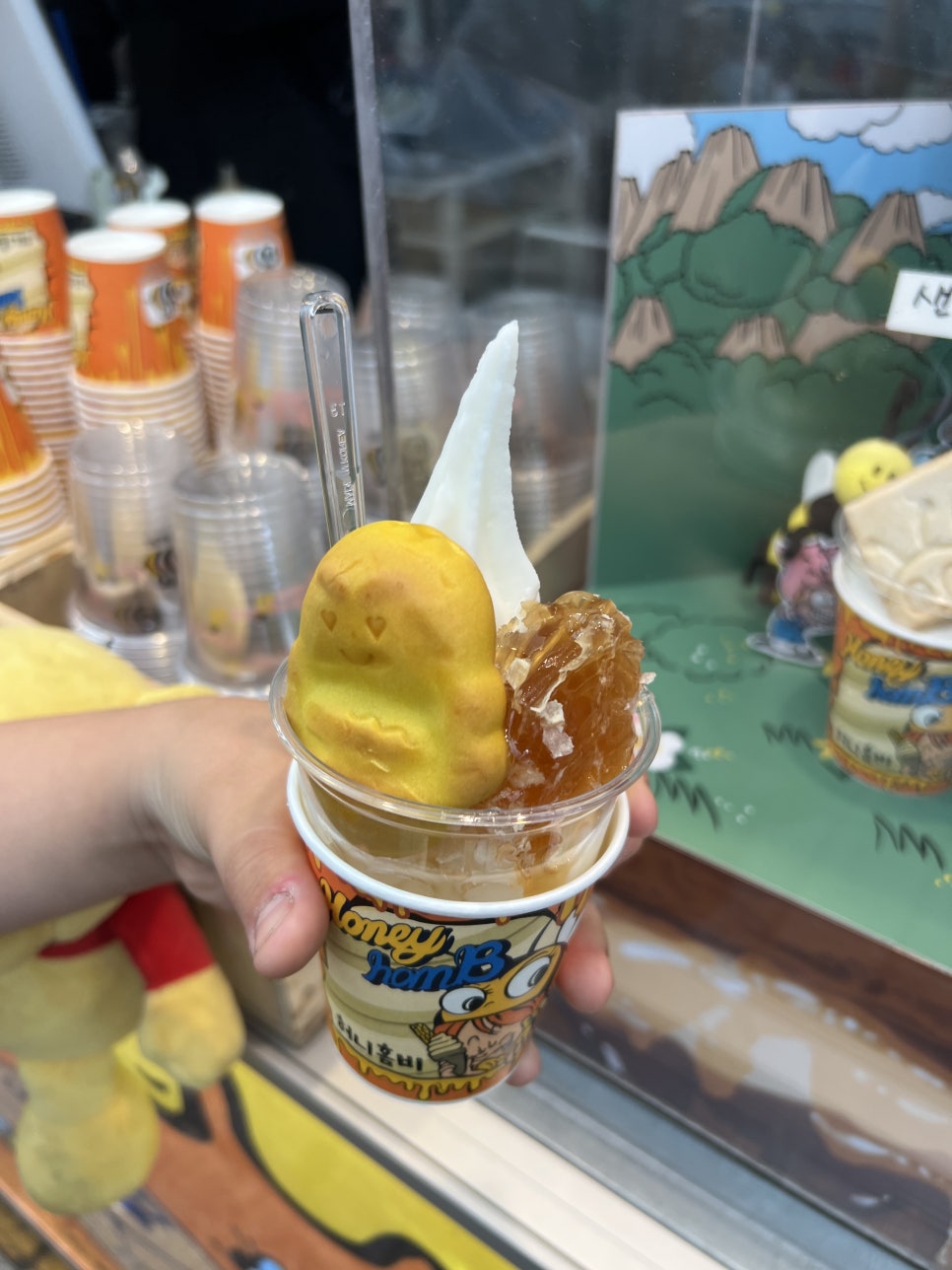 na0179가 찍은 조리대에는 직원이 벌집을 칼로 떼어 내 컵 두 개에 나눠 올리는 손길이 담겨 있습니다.