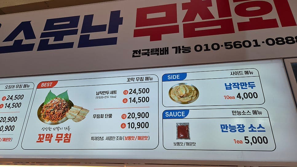 the_manura가 매장 앞에서 찍은 세로 현수막에는 '강원도의 빨간 맛, 오징어무침 & 납작만두'라는 문구와 함께 방송에 소개된 장면들이 사진으로 담겨 있습니다.