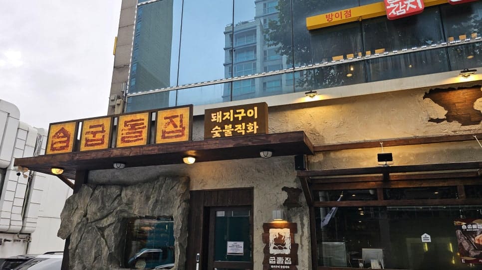 inho5062가 촬영한 송리단길의 오래된 상가 건물입니다. 돌로 마감한 외벽과 손글씨 간판이 새로 생긴 카페들 사이에서도 여전히 그 자리를 지키고 있습니다.