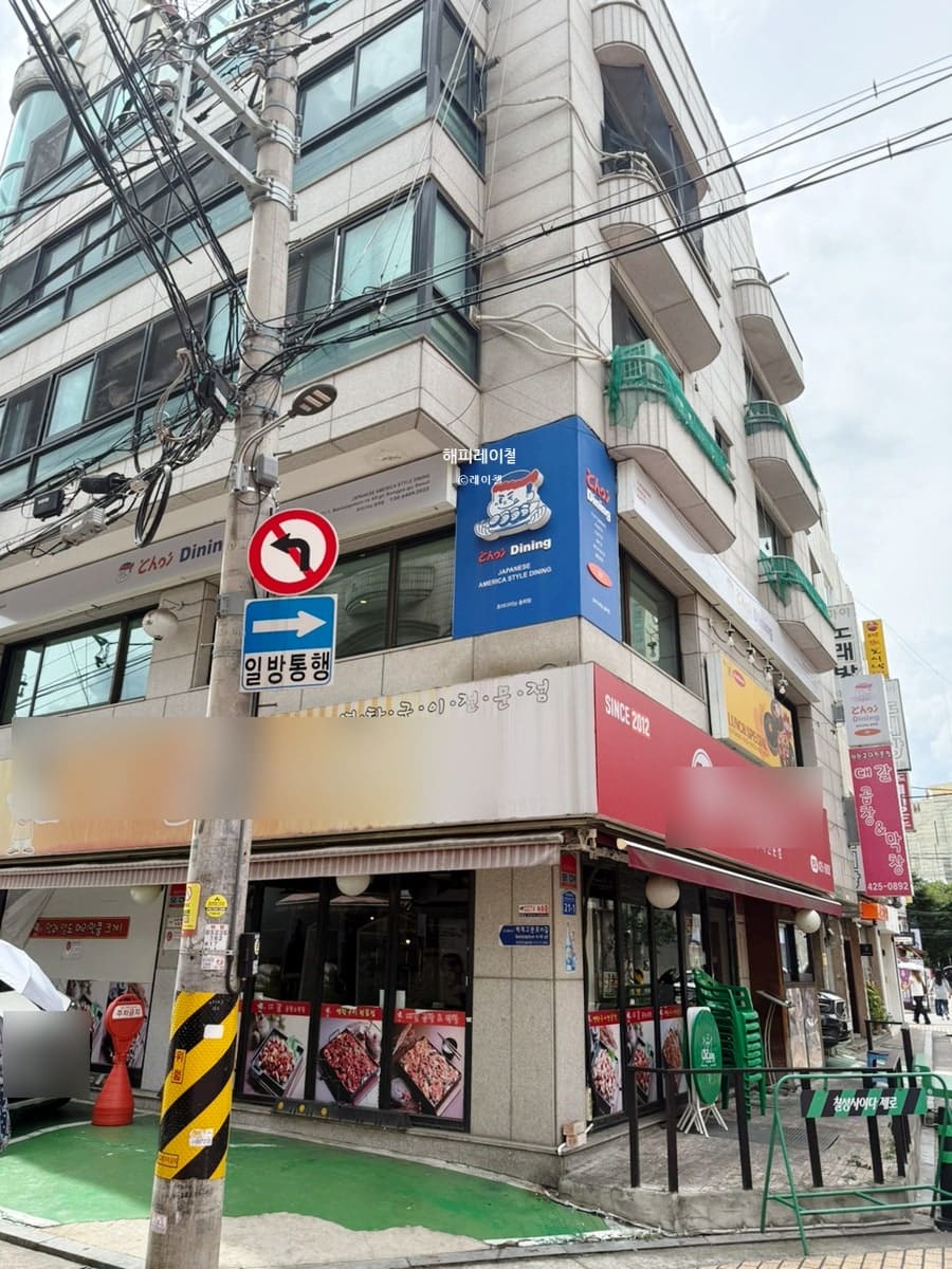swih가 촬영한 송리단길의 골목 모퉁이입니다. 표지판과 낮은 건물들이 어우러진 이 자리는 큰길에서 한 번 꺾어 들어가야 나오는 조용한 구간입니다.