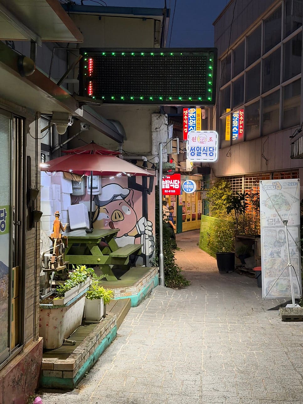 hongane2013은 돼지와 소 캐릭터가 그려진 벽화와 네온 간판이 있는 골목 입구를 먼저 찍고,