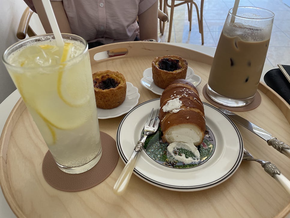 es_favorites는 레모네이드와 아이스커피, 타르트 두 조각과 크림을 채운 소금빵을 한 테이블에 올려 담았습니다.