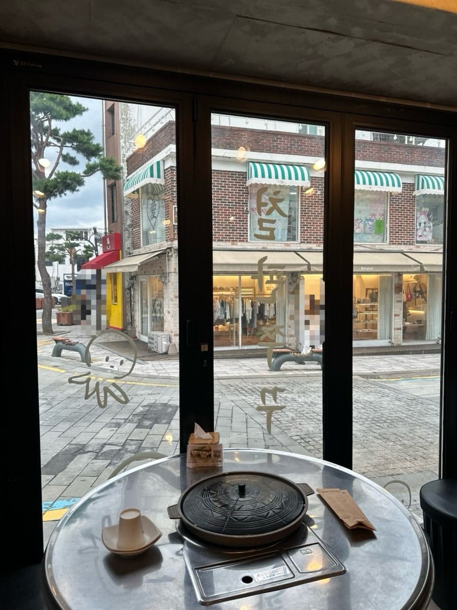 창가에서 행리단길의 저녁 풍경을 보며 식사하는 모습. 폴딩도어를 통해 보이는 행궁동의 분위기