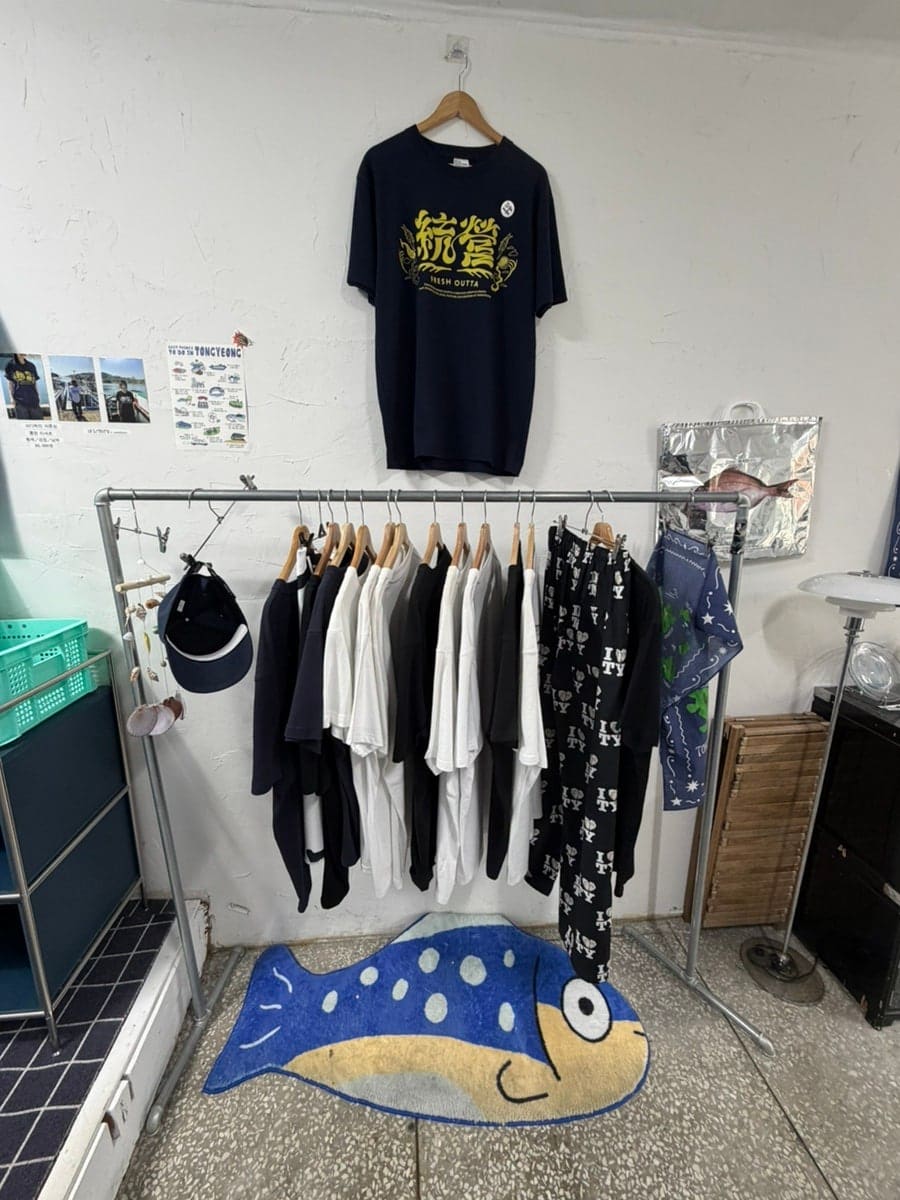 happy_10g가 남긴 사진입니다. 티셔츠가 걸린 행거 아래 물고기 모양 러그, 그리고 채반에 얼음과 레몬 조각 모형을 깔고 키링을 진열한 좌판을 담았는데,
