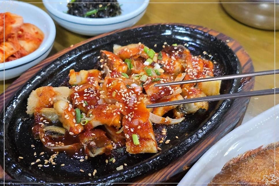 soheemom0212이 남긴 사진입니다. 생선구이와 고등어조림, 열 가지 반찬이 놓인 상 전체와 불판 위 양념장어를 담았는데,