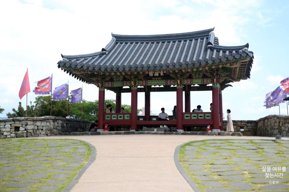 jho8027이 남긴 사진입니다. 카페들이 늘어선 오르막 골목과, 그 끝에서 만나는 동포루 정자 전경을 담았는데,