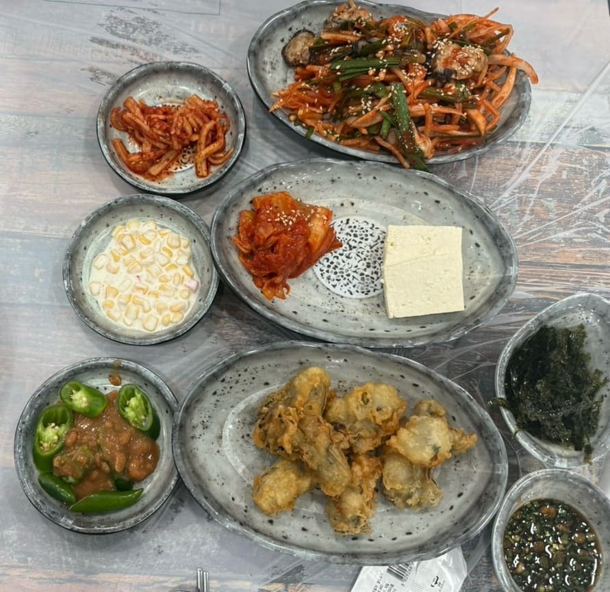 nanni_s가 주말 오후에 방문해 남긴 사진입니다. 굴튀김과 밑반찬이 가득 놓인 상, 그리고 나물을 넣어 부친 전 세 장을 담았는데, 본인은 굴튀김이 특히 맛있었다고 적었습니다.