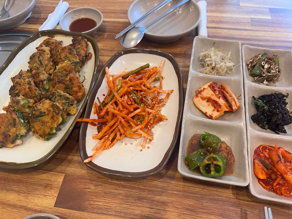 nadri_log가 모둠물회와 전복돌솥밥을 함께 주문한 자리에서 찍은 사진입니다. 반찬 접시와 테이블에 놓인 주전자까지 담아,