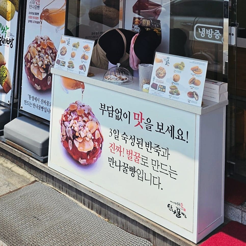 power___j가 남긴 매장 외관 사진입니다. 건물 전체를 덮은 얼굴 간판과, 지나가는 사람이 맛볼 수 있도록 마련된 거리 시식대를 담았는데,