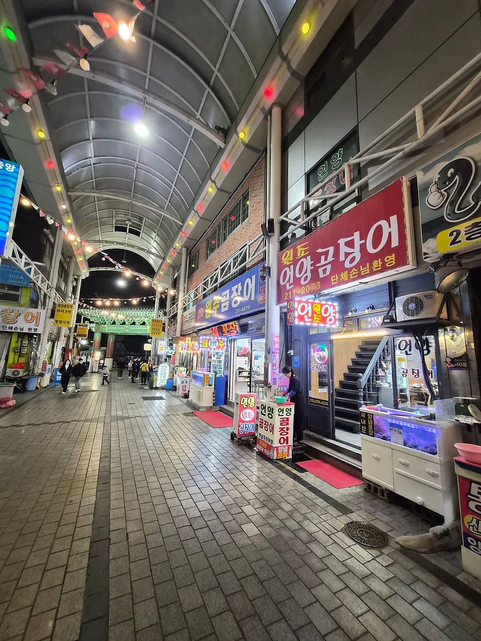 wwwbehappy가 남긴 사진입니다. 중앙전통시장 청년야시장 입구와, 그 안쪽 곰장어 골목에 늘어선 간판들을 함께 찍었습니다.