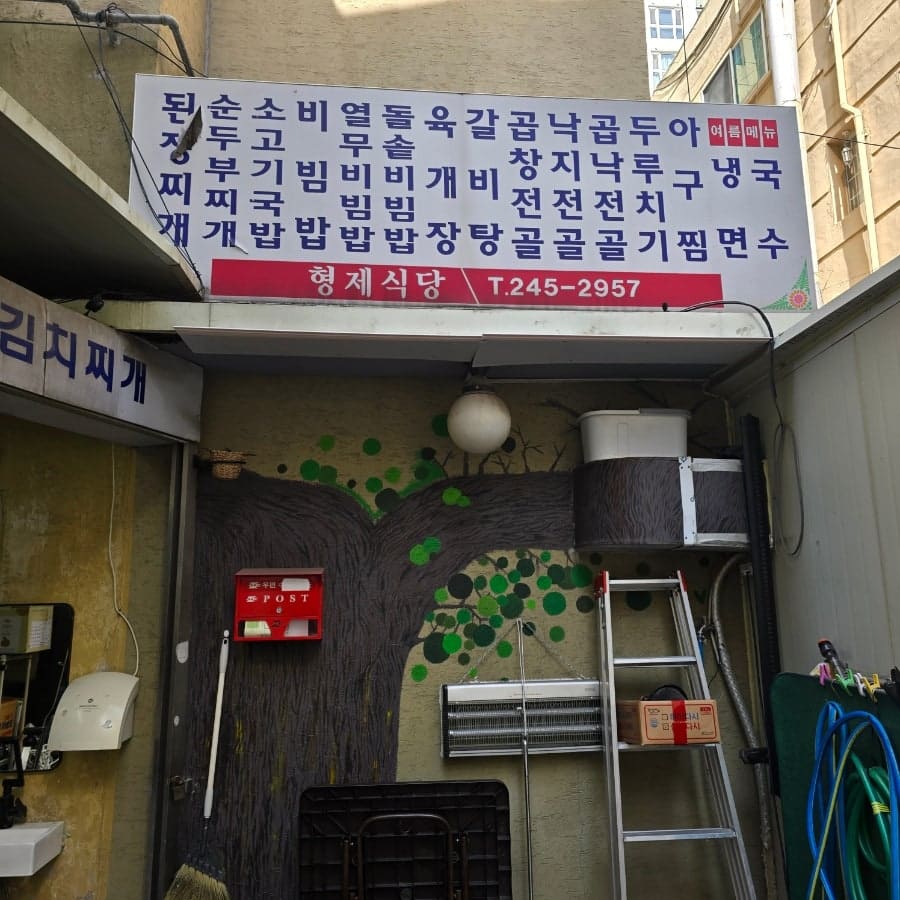 tpwhd669이 남긴 사진입니다. 꽃무늬 벽지와 낡은 선풍기가 그대로인 좌식 식당 내부와, 메뉴 글씨가 빼곡한 외벽 간판을 함께 담았습니다.