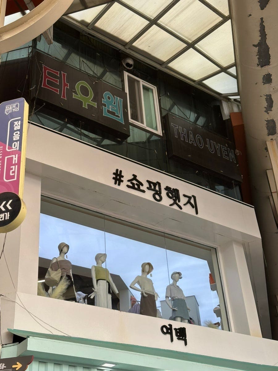 pyw4920이 찍은 젊음의거리 옷가게 매장입니다. 옛 상호 간판 위에 새로 연 매장 간판과 온라인 쇼핑 플랫폼 입점 안내가 함께 붙어 있는 모습을 보여줍니다.