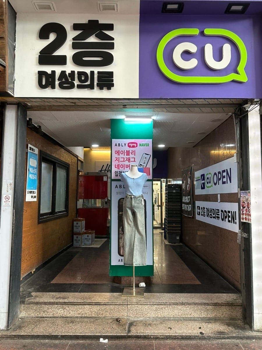 pyw4920이 찍은 젊음의거리 옷가게 매장입니다. 옛 상호 간판 위에 새로 연 매장 간판과 온라인 쇼핑 플랫폼 입점 안내가 함께 붙어 있는 모습을 보여줍니다.