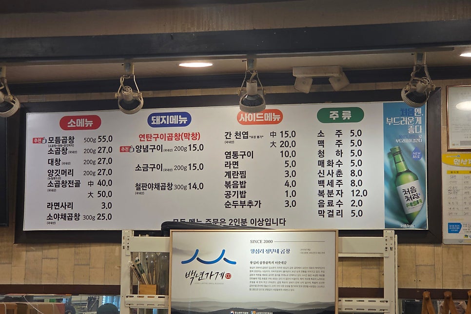younging_320은 정부네 곱창 내부의 백년가게 선정 현수막과 소·돼지 메뉴판을 담았다. 오래 버틴 가게일수록 벽에 걸어 둘 인증이 늘어난다.
