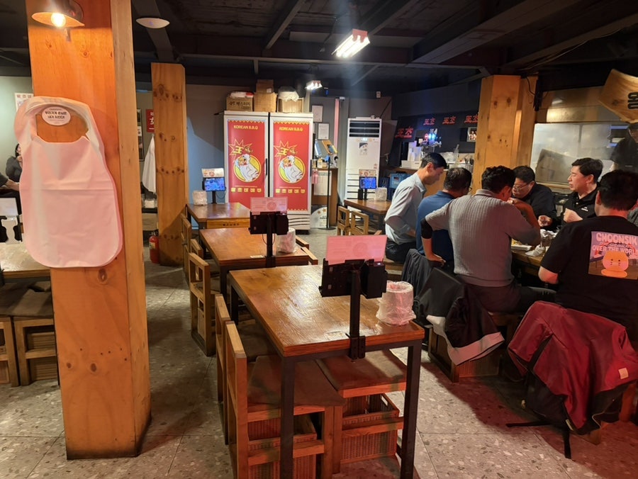moments301은 태블릿으로 주문하는 왕초바베큐의 북적이는 내부와, 둥근 창 너머 어두워진 거리를 나란히 남겼다. 저녁 피크 시간대의 공기가 그대로 느껴진다.