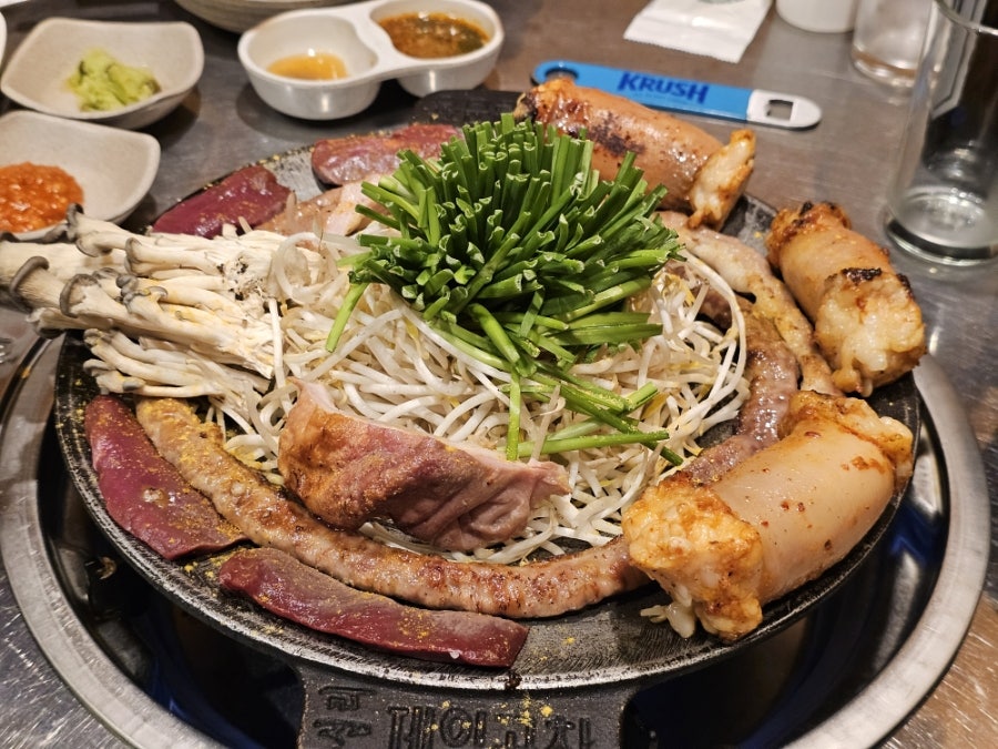 goldtop3321이 화덕에서 초벌로 구워져 나온 곱창과 대창을 가까이서 찍었다. 부추와 콩나물 사이로 기름이 아직 지글거린다.