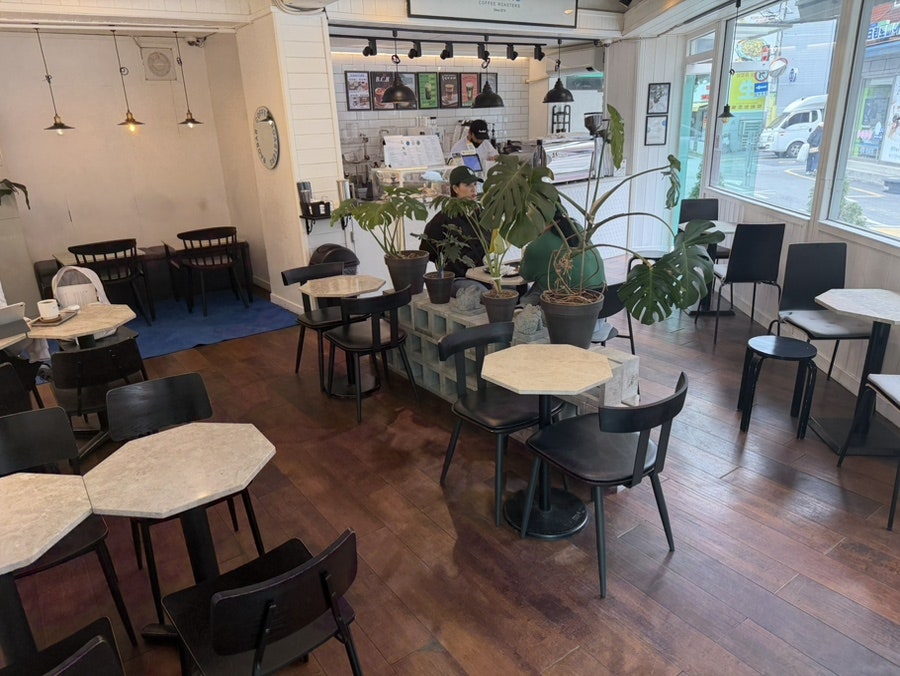 gabjin87은 시멘트 벽돌을 화분 받침 삼아 놓은 테이블과 창밖으로 거리가 내다보이는 넓은 좌석, 원두를 내리는 카운터 안쪽까지 매장 구석구석을 찍었습니다.