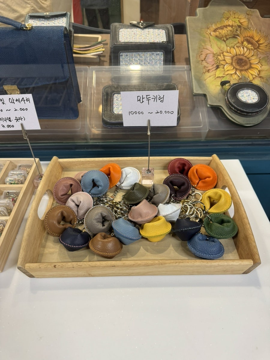 nkk4584가 담은 블랙베어크래프트입니다. 가동 3번길 6호, 파란 문에 걸린 작은 간판과 유리 진열장 안의 가죽 소품들이 보입니다.