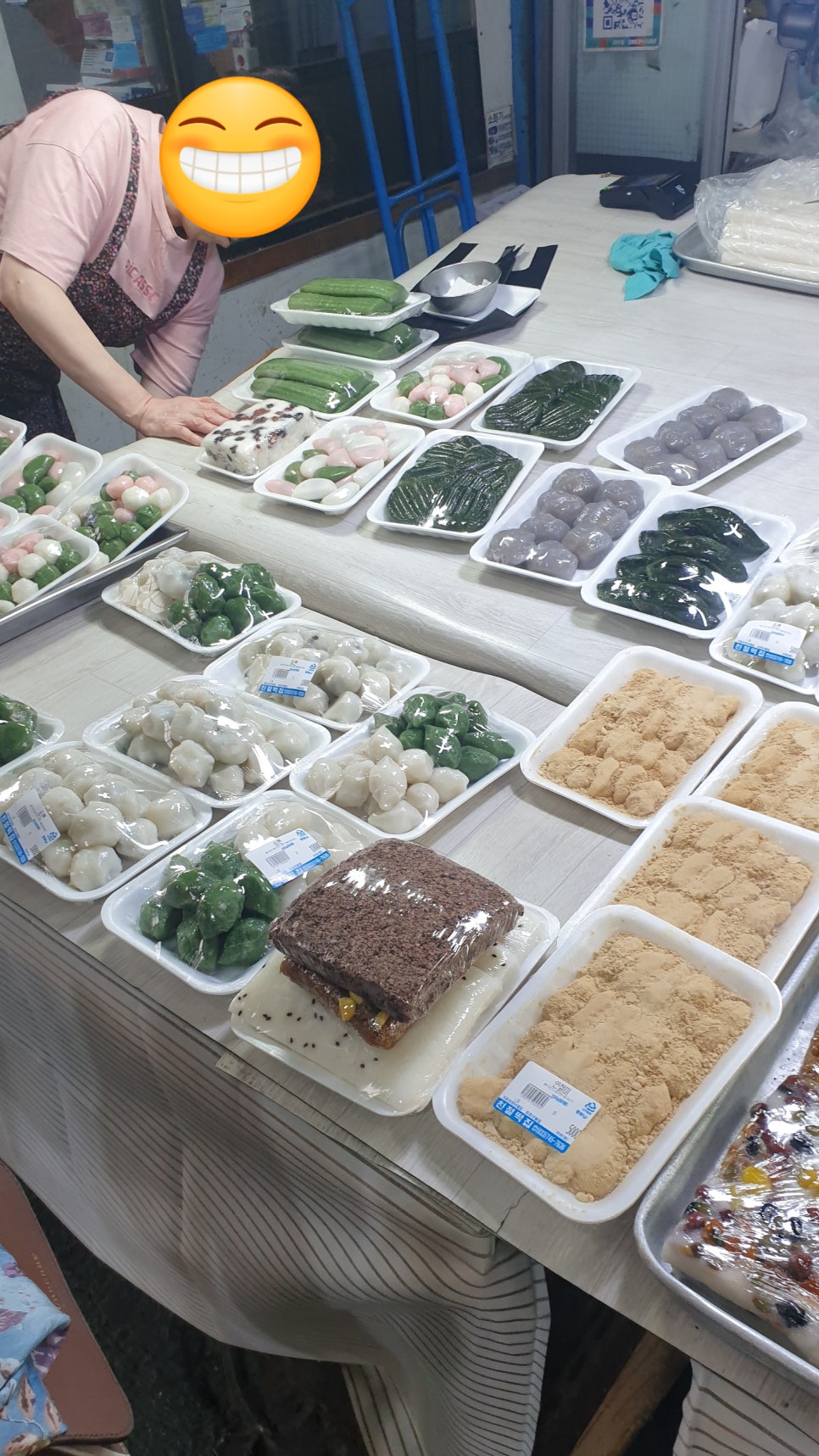 kimjk20이 담은 친절떡집입니다. 나무 간판에 가게 이름과 전화번호가 또렷하게 새겨져 있고, 안쪽에서는 에이프런을 두른 주인이 떡이 담긴 쟁반을 정리하고 있습니다.